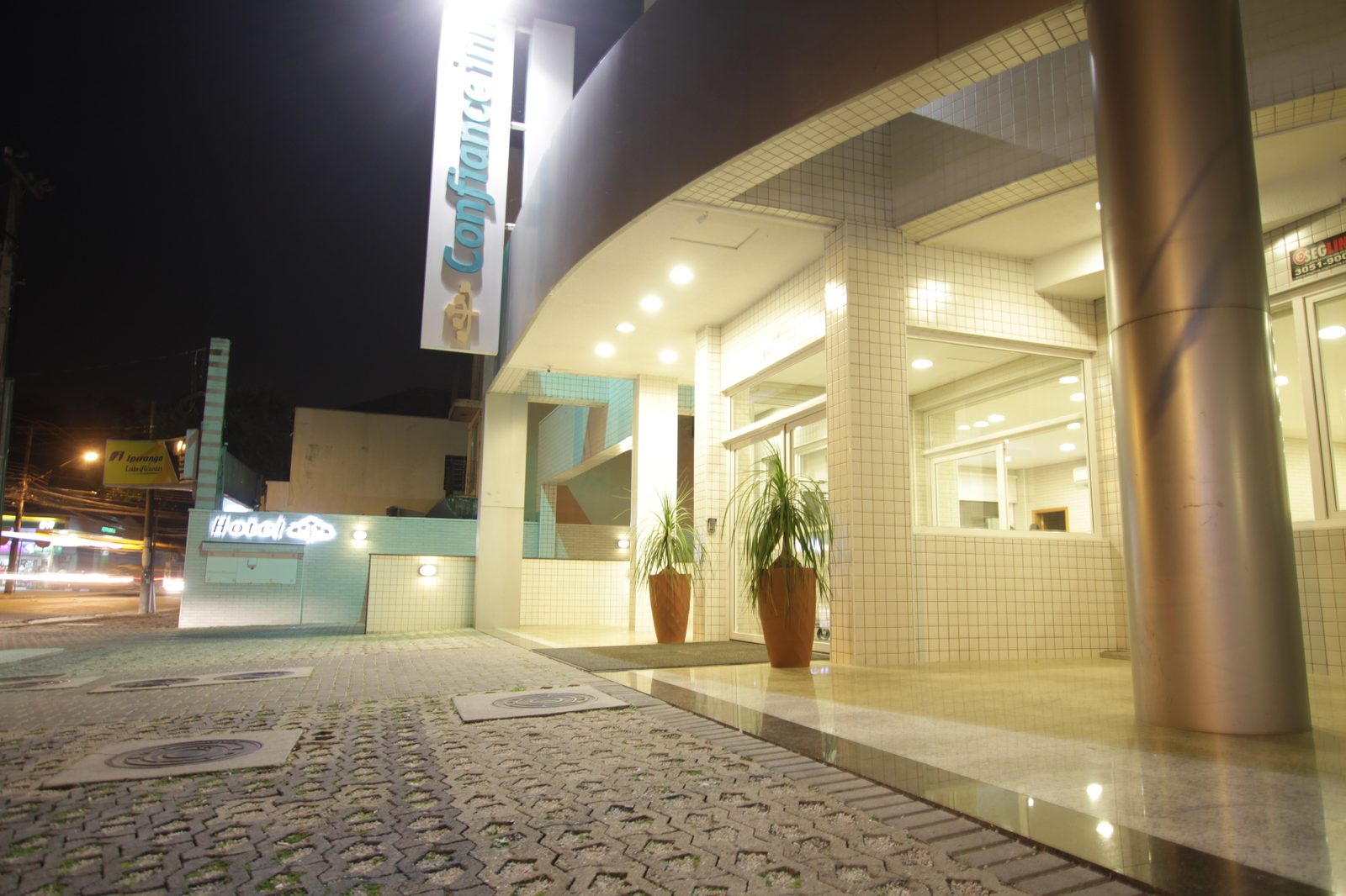 Fachada iluminada do Hotel Confiance Centro Cívico